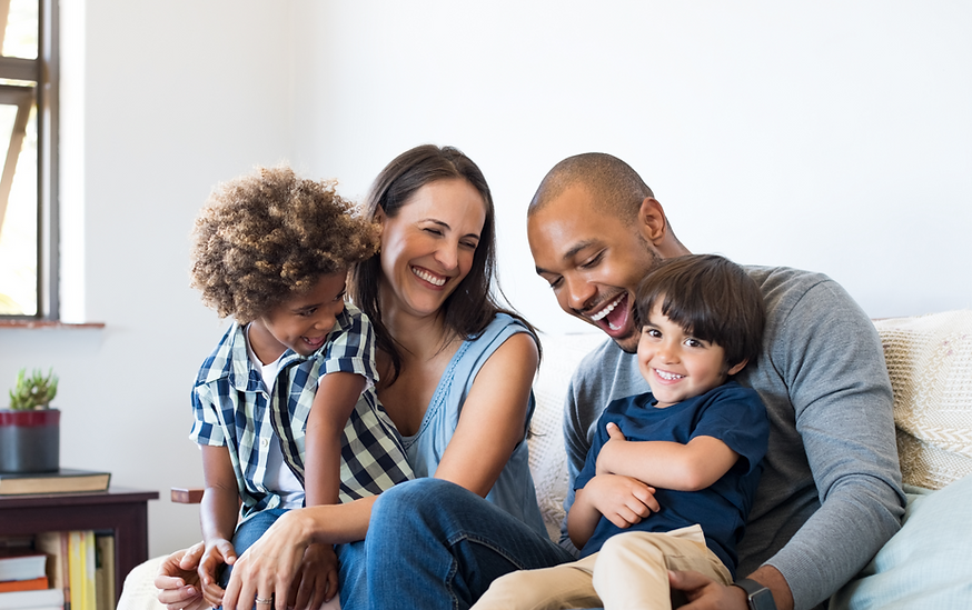 Smiling family of four, parents and children, happily together at Home.
