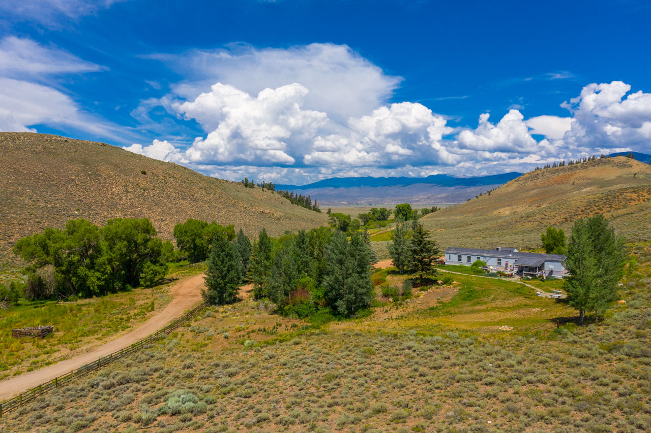 Needle Creek Ranch - image of home on hill with mountains in the background