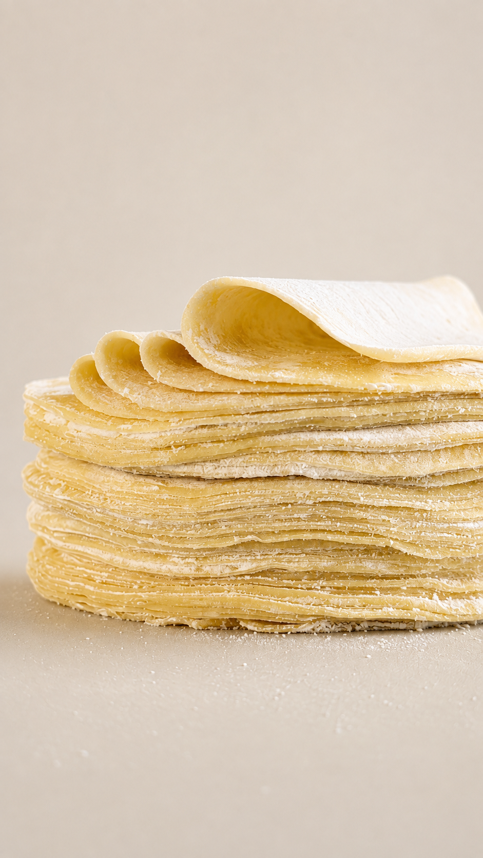 Stack of fresh Wantan and Sui Kow dumpling skins lightly dusted with flour