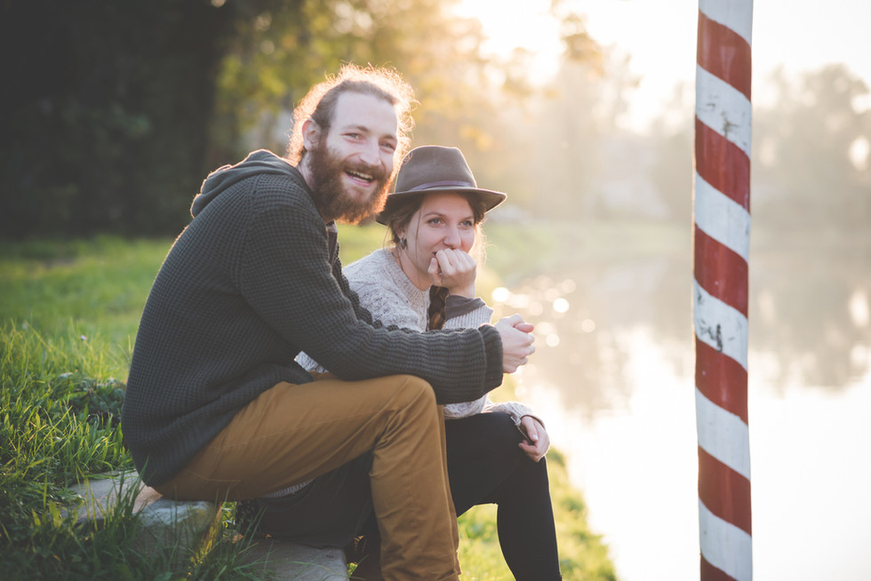 a man with a beard and a woman with a hat sit next to each other