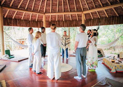 Participants of the retreat are standing in a circle sharing intentions before an ayahuasca ceremony