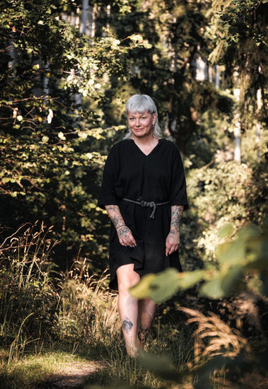 Frau in schwarzem Kleid im Wald
