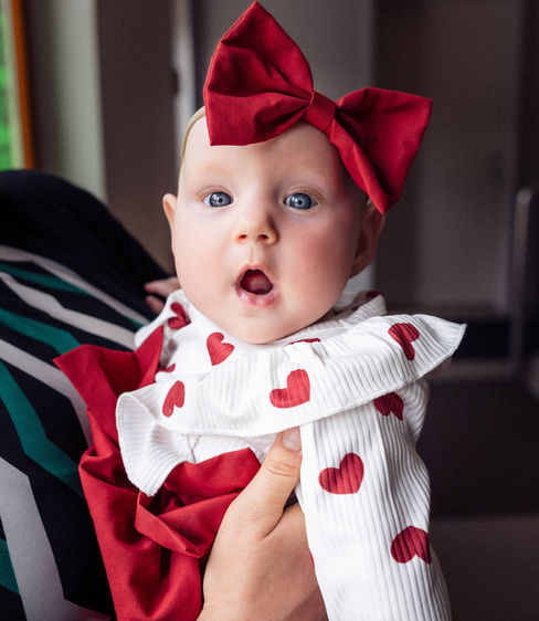 Baby mit roter Schleife und Herzchen-Kleid, Neugeborenen Fotografie mit der lieben Maya.