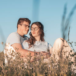 Ein junges Paar sitzt entspannt im Gras, Mini Shooting Paarfotos Jena & deutschlandweit.