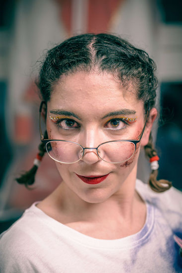 Junge Frau mit Brille und Zöpfen, Blick in die Kamera, für ein Fotoshooting.