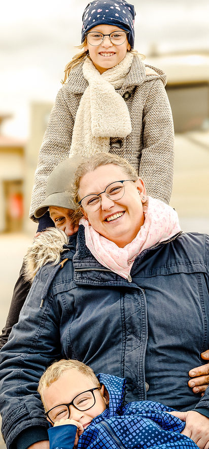 Glückliche Familie im Winter: Mutter, Vater, Tochter und Baby genießen einen Ausflug.