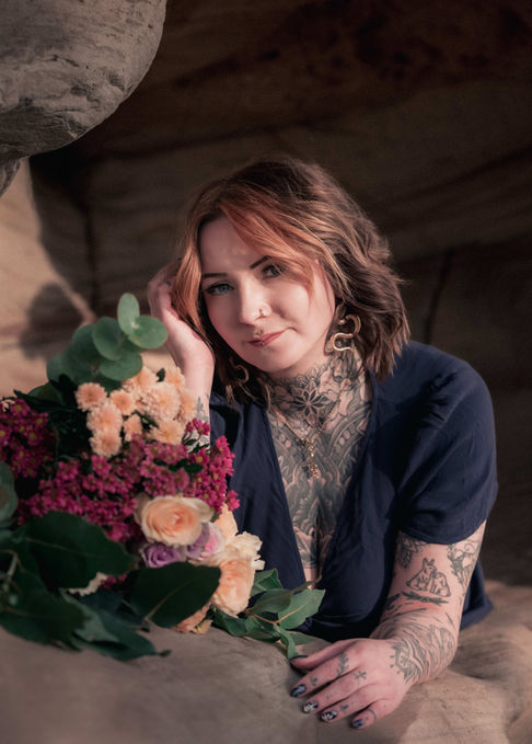 Portraitfotografie: Frau mit Tattoos und Blumen.