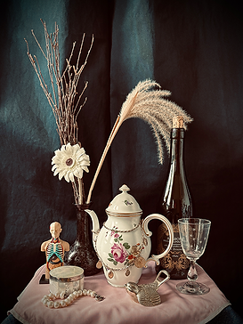 Stillleben 6 - Vase mit getrockneten Blumen, Augartenporzelann Teekanne, Goldkette, Weinflasche, Weinglas, Silber Flaschenöffnerin Vogelform, Anatomiemodell Torso, Perlmutdöschen, Perlarmband, Tischdecke rosa, dunkelblauer Vorhang als Hintergrund