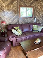 Cabin with large leather couch and lounge chair
