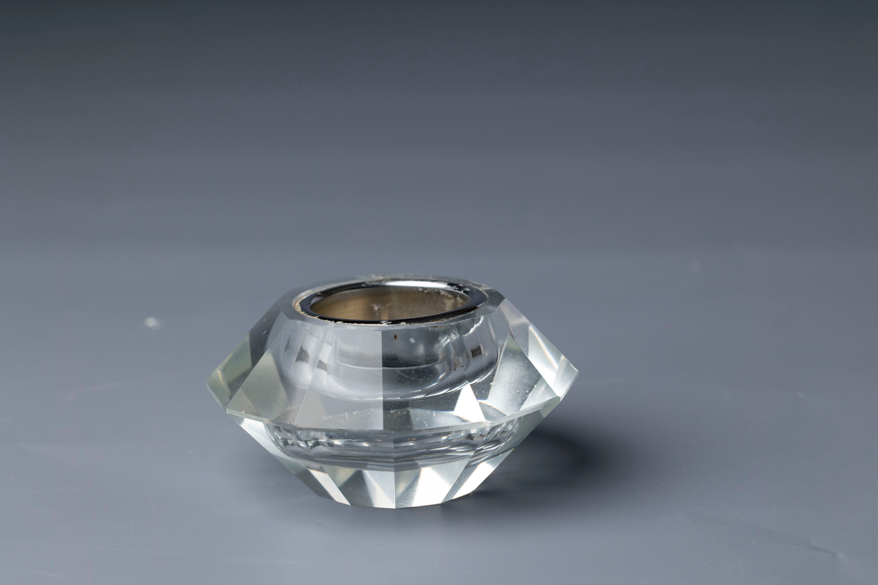 This item is a vintage faceted glass or crystal candle holder, designed to refract light attractively.