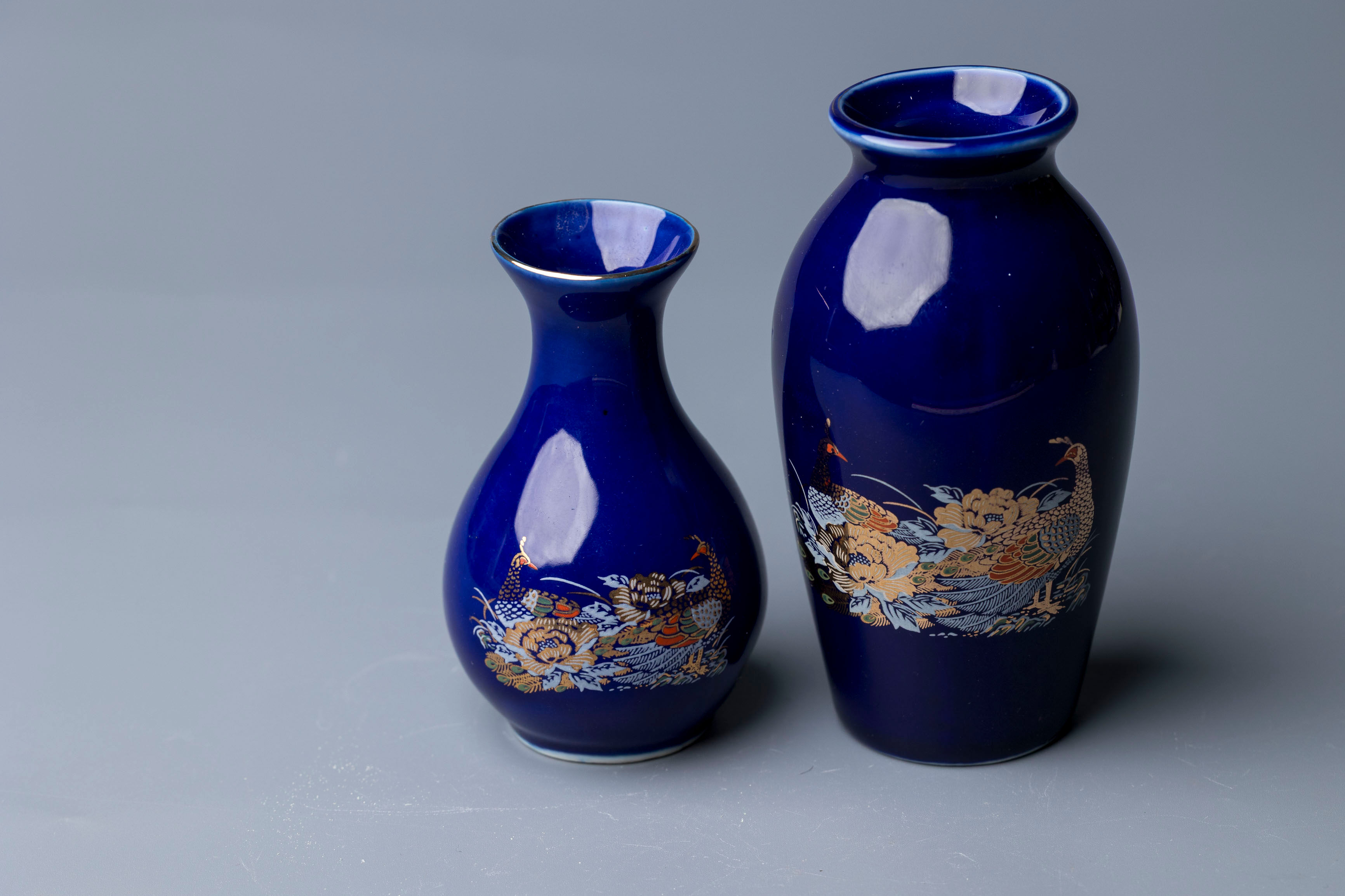 This is a matched pair of Japanese export porcelain vases, notable for their rich cobalt blue glaze and detaile