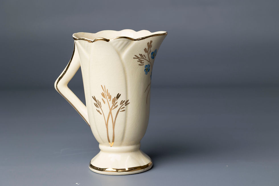 This Arthur Wood piece is a charming English jug featuring a flared, trumpet -shaped form with distinctive angular handle