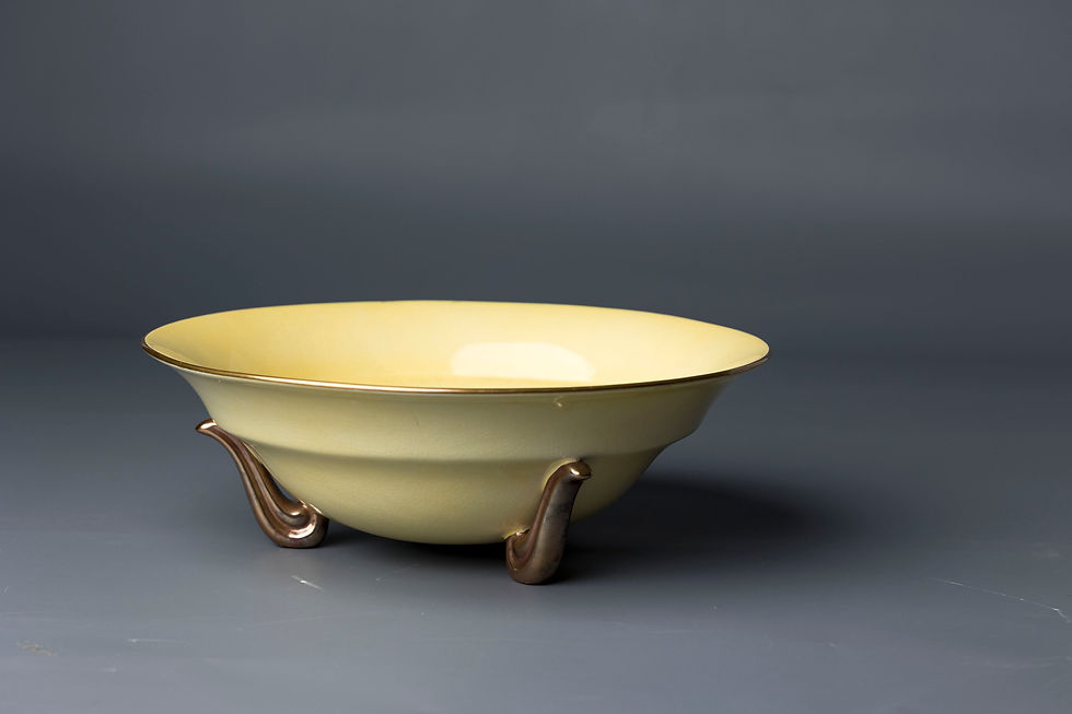 This elegant mid-century footed bowl by Carlton Ware, finished in a glossy custard yellow glaze with uniform fine crazing