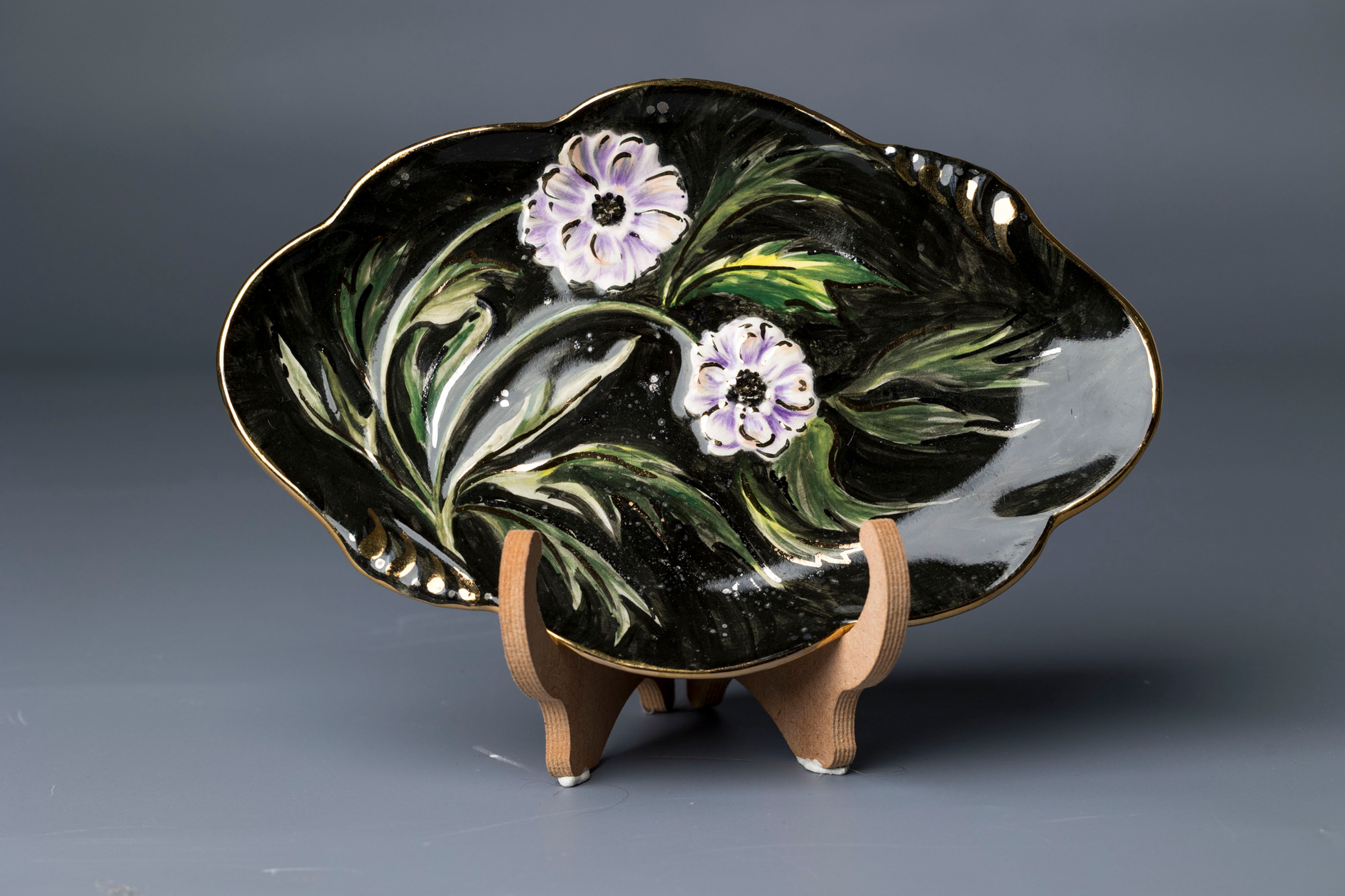 This is a decorative lobed edge bonbon or display dish featuring vivid hand painted enamel flowers in soft iridescent tones