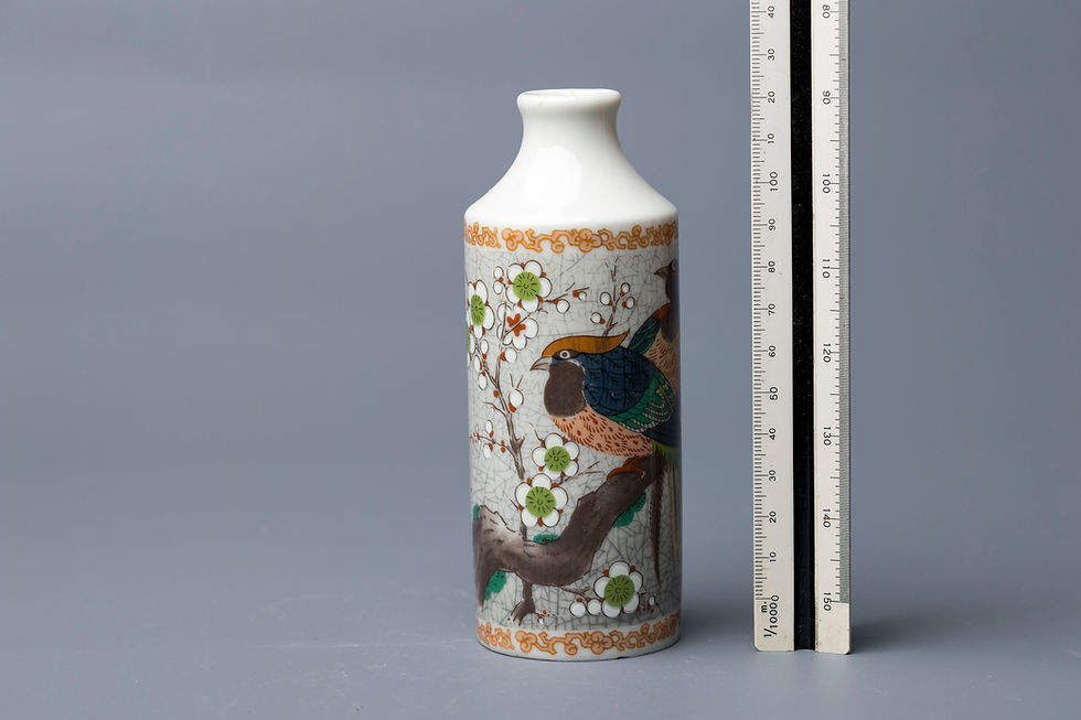 This tall cylindrical porcelain bottle vase features a delicate and popular Chinese design, including: Hand-painted enameled