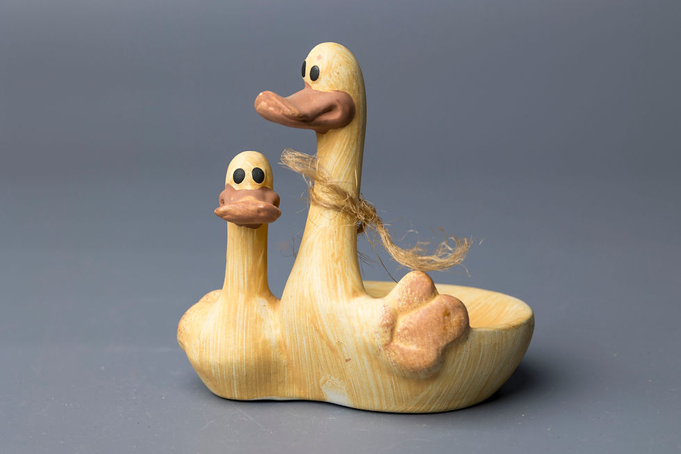 This figural dish uses clever design to imitate natural carved wood while being made of glazed ceramic.