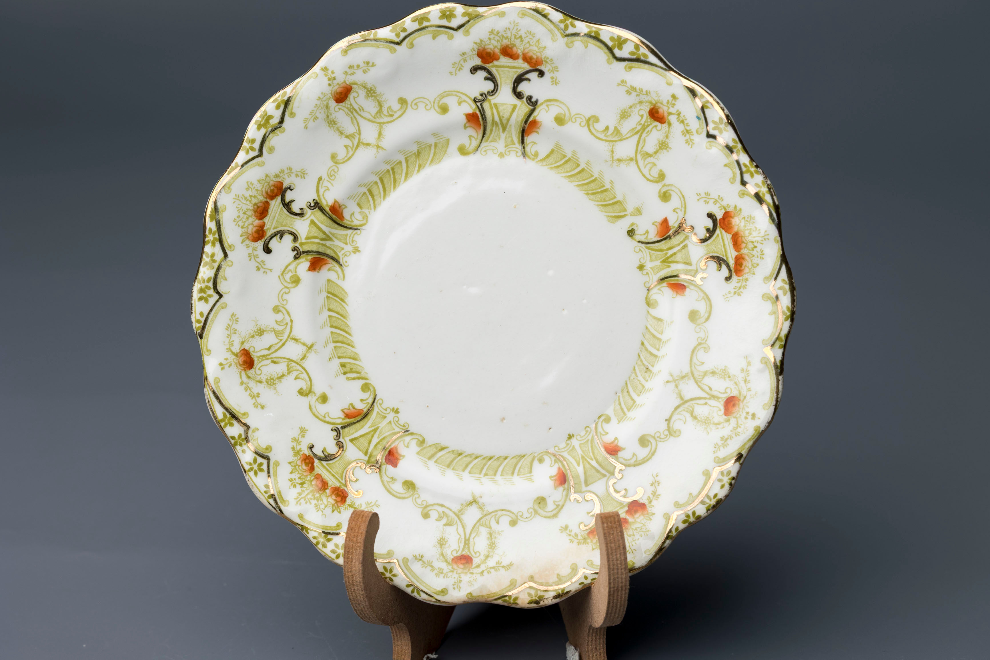 This is a decorative scalloped-edge porcelain plate produced by J.H.C. & Co