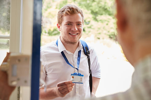 Male care worker showing ID to senior man at his front door.jpg