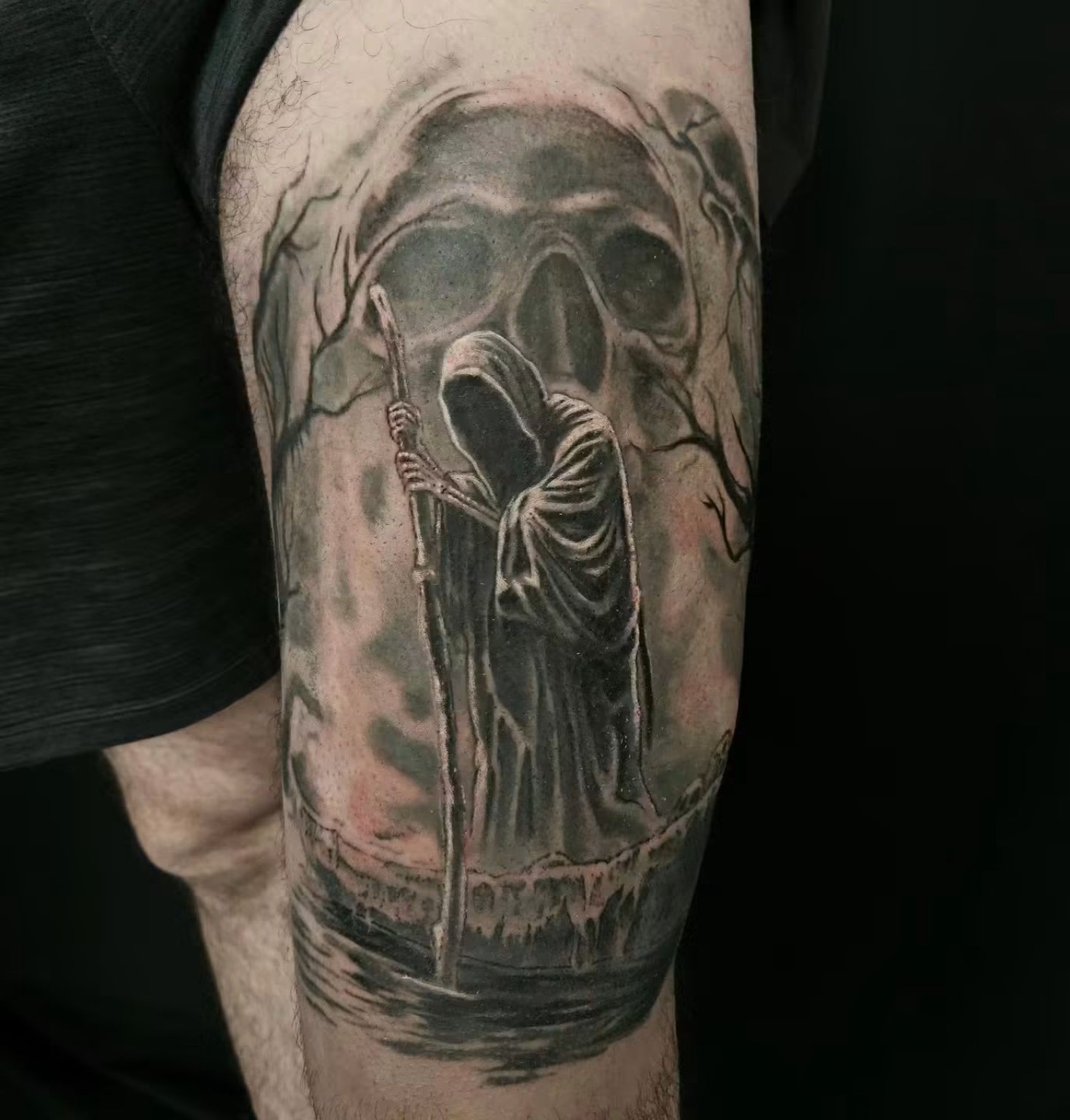 Black and grey Charon tattoo with a hooded ferryman, staff and looming skull