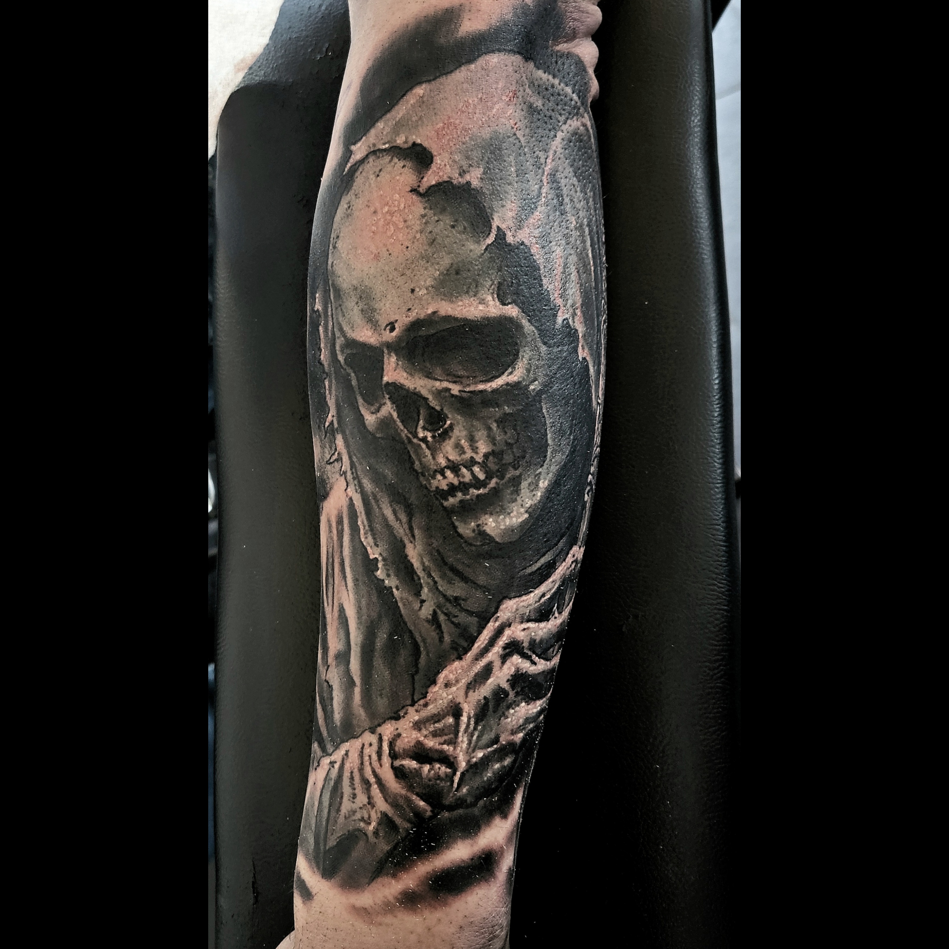 Black and grey skull and roots forearm tattoo