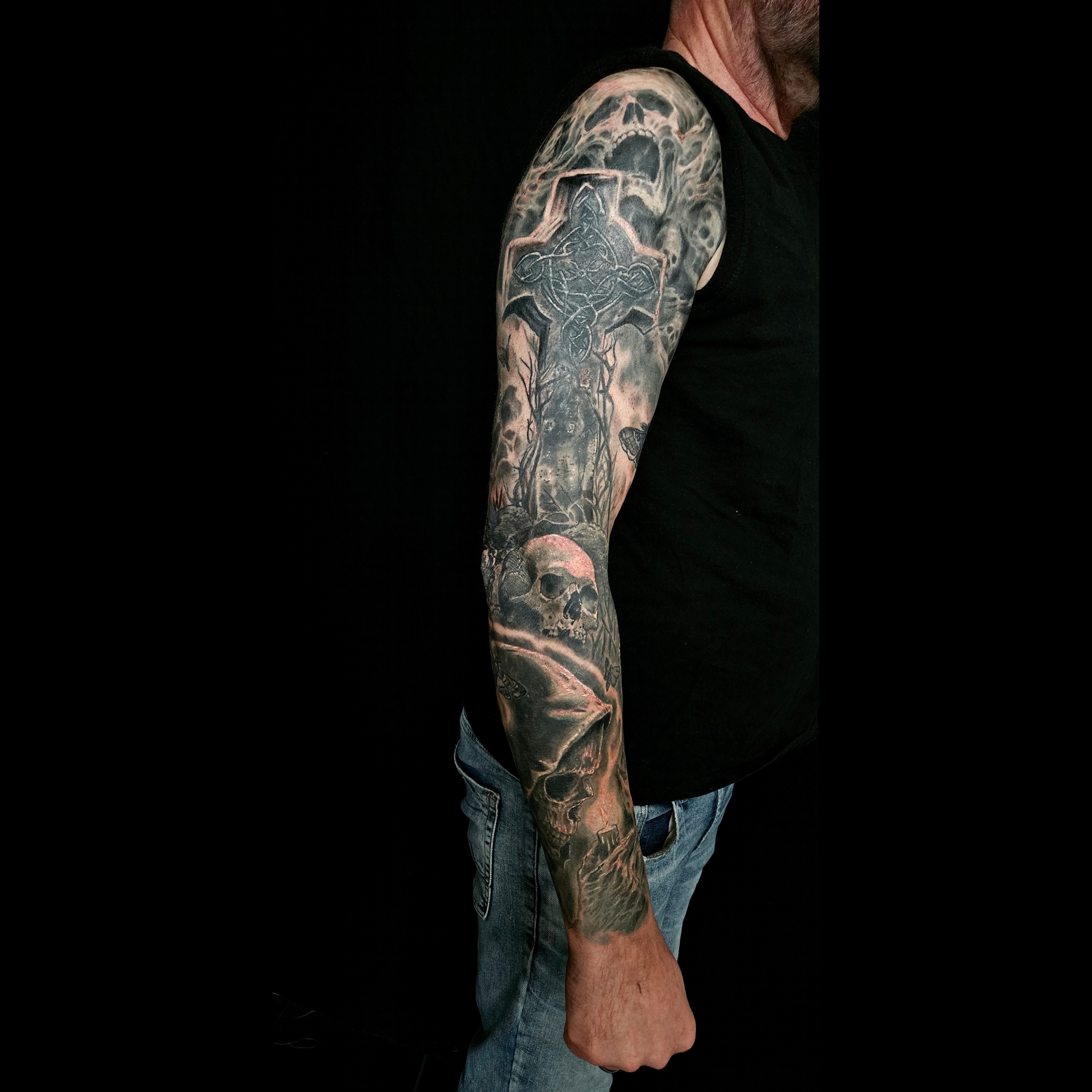 Black and grey sleeve with a large cross, skeleton and lantern