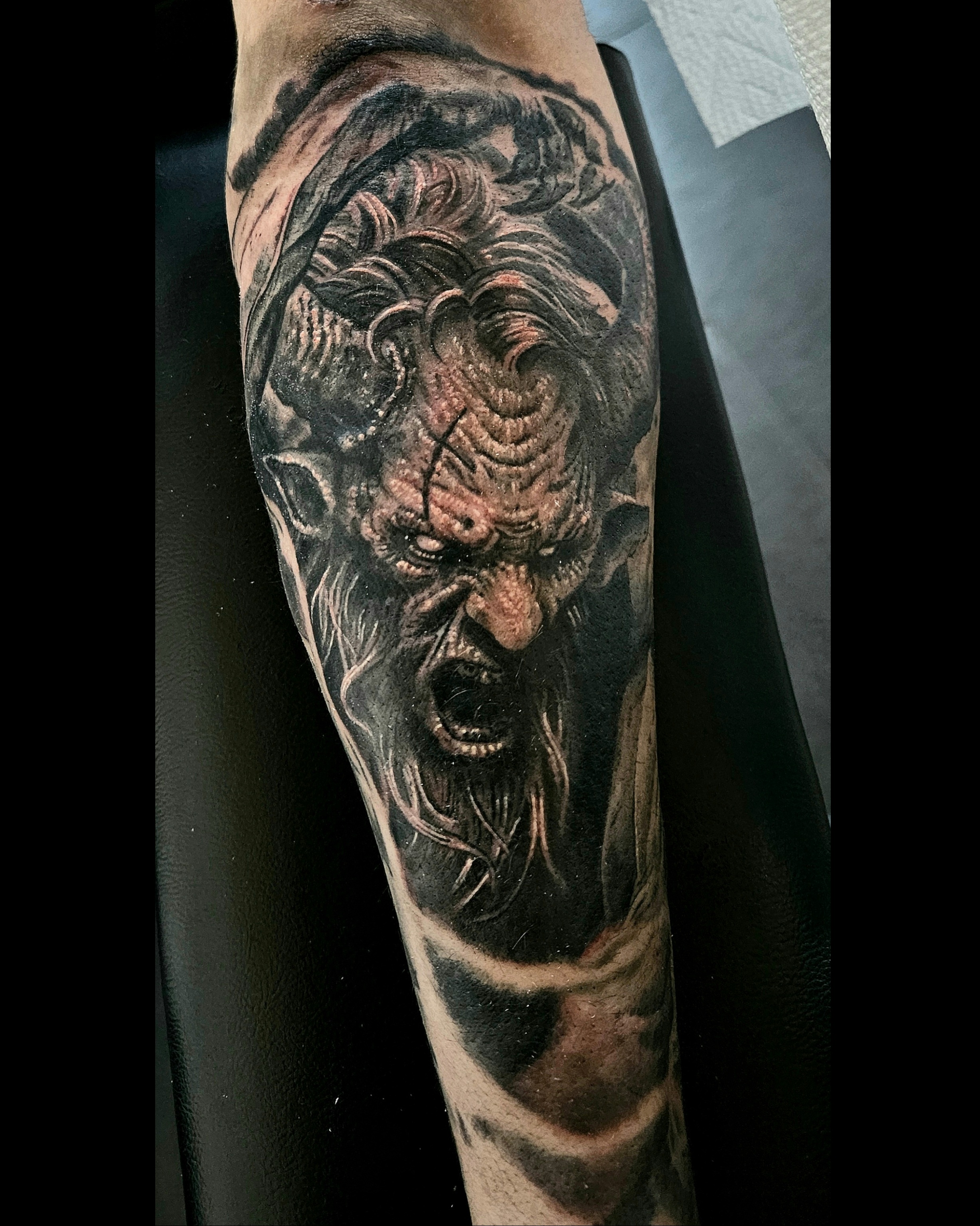 Dark illustrative goblin character forearm tattoo