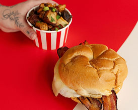 Dandies menu image represented by a breakfast sandwich with side of potatoes.