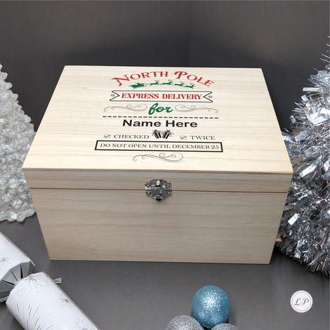 A wooden Christmas box labelled North Pole Express Delivery box, Name Here, Checked Twice. Do not open until December 25, sur
