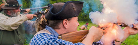 A muzzleloader fires during a battle reenactment