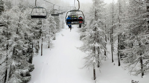 A ski lift in between sno covered trees in Claviere, Italy