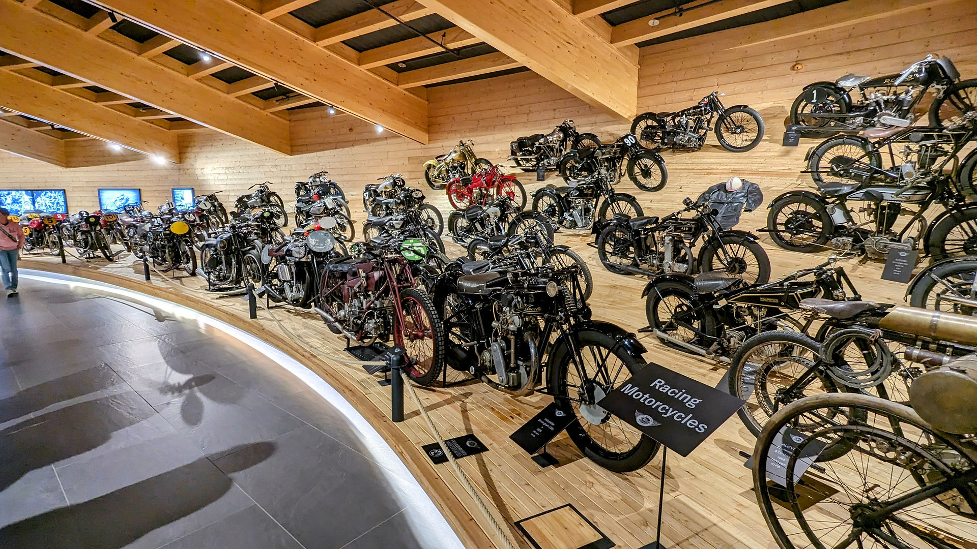 The banked wall of race bikes in the Top Mountain Motorcycle Museum