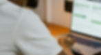 Image of a guy scrolling on his laptop, working on a website.