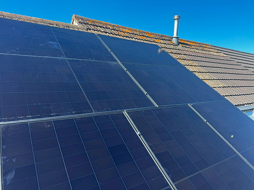 Solar panels installed on a residential roof under clear blue sky