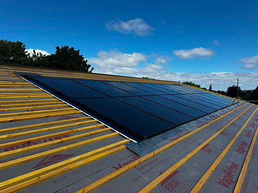 Solar panels installed on an unfinished roof with exposed battens and vapor barrier membrane