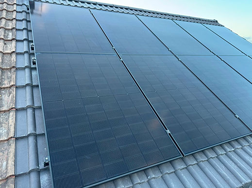 Black solar panels mounted on a tiled residential roof