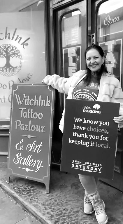 Black and white photo of tattoo artist Carolina standing outside the shop front