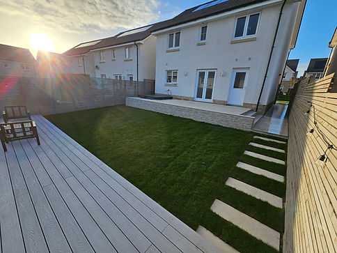 Garden in a house with decking, fencing, patio and a lawn