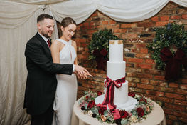 Elegant tall three-tier fondant wedding cake displayed at a venue in Yorkshire