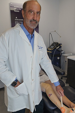Roger Schecter, MD performing a wound assessment