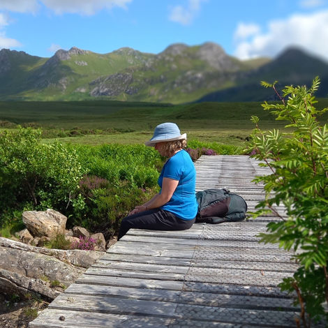 Julia Complin sitting on wooden bridge in Scottish glen