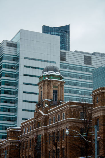 Old domed building with snow, modern skyscrapers behind