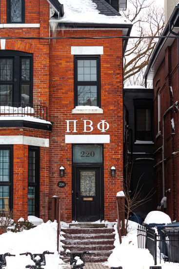 Brick building with Greek letters ΠΒΦ and house number 230 in snow.