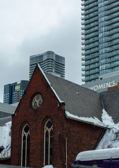 Historic brick building with snow, modern towers