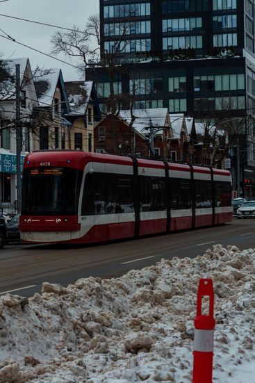 Red and white streetcar on a snowy city street
