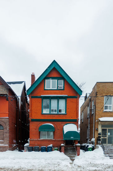 Red-orange house with teal roof in snow