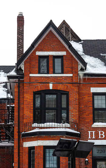 Red brick house with snow on roof