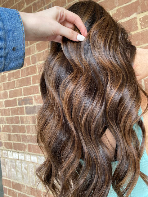 Dimensional brunette hair with subtle highlights and lowlights for a soft, natural look in Suwanee, GA.