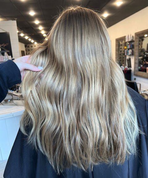 Dimensional blonde with a blend of highlights and lowlights for added depth and brightness in Suwanee, GA.