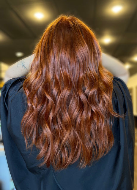 Natural redhead color with soft red hues and shine for a polished, vibrant look in Suwanee, GA.