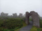 The ancient and imposing ruins of the Rock of Cashel, silhouetted against a cloudy sky, stand majestically amidst a historic cemetery.